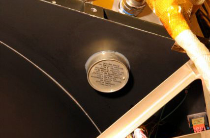 H κάψουλα με την τέφρα του Τόμπω κολλημένη σε μια ελεύθερη επιφάνεια του New Horizons (Πηγή: Johns Hopkins University Applied Physics Laboratory)